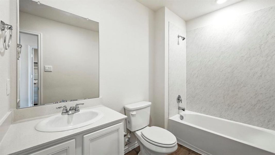 Bathroom featuring a white vanity with an integrated sink, chrome faucet, and a large wall-mounted mirror