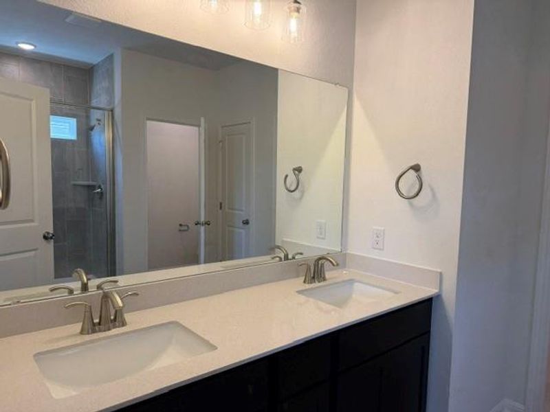 Dual vanity with integrated sinks and brushed nickel faucets Dual vanity with integrated sinks and brushed nickel faucets