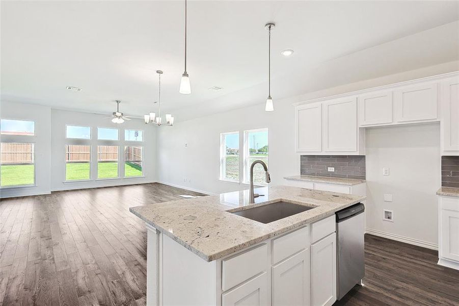 Kitchen with white cabinets, sink, and dishwasher