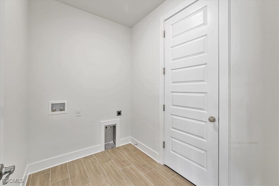 Laundry room featuring wood finish floors, hookup for a washing machine, and hookup for an electric dryer