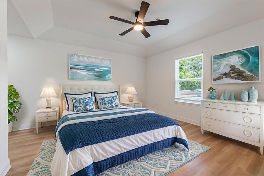 Primary bedroom with HIS/HER walk-in closets, high ceilings, vinyl flooring, ceiling fan, and 2" blinds. Virtually staged.