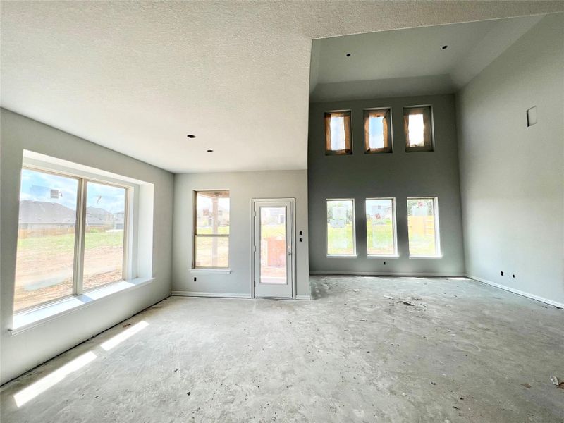 Unfurnished living room featuring baseboards and a textured ceiling Unfurnished living room featuring baseboards and a textured ceiling