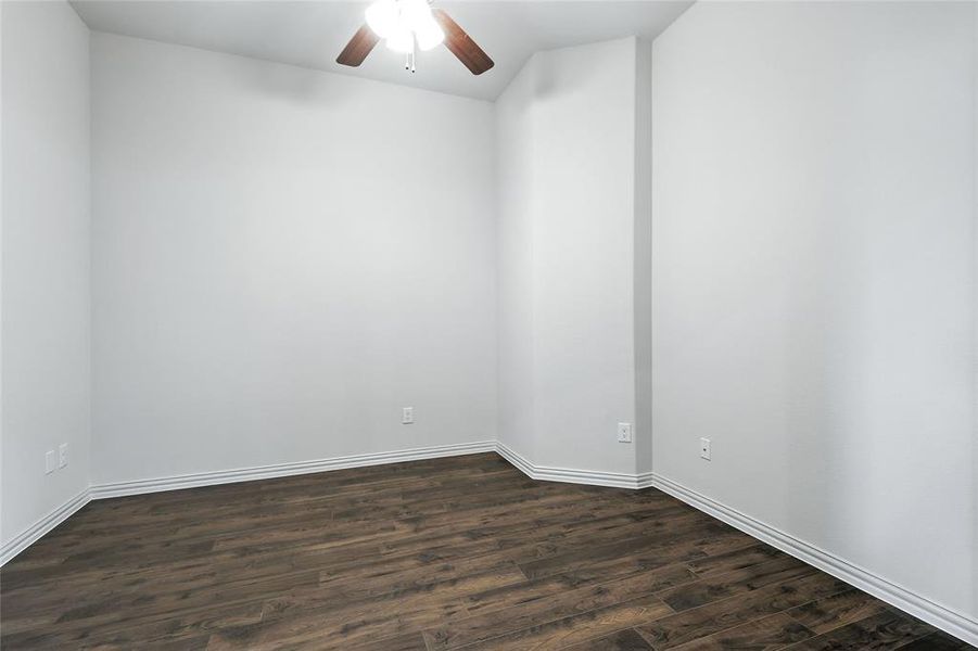 Empty room featuring dark wood-style floors and ceiling fan Empty room featuring dark wood-style floors and ceiling fan