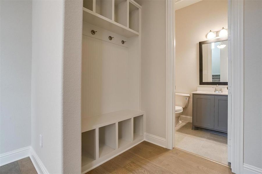 Mudroom with light hardwood / wood-style flooring and sink