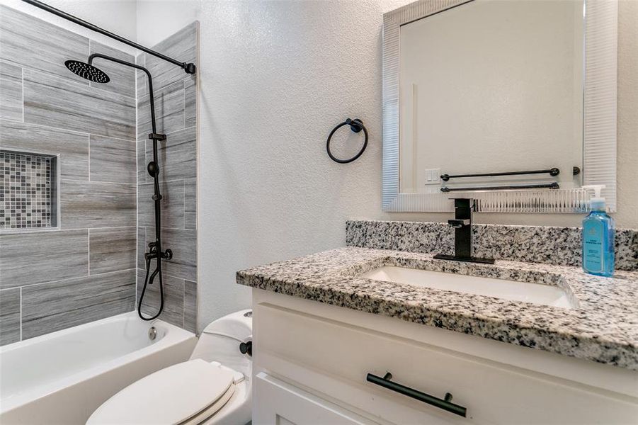 Full bath featuring a textured wall, tub / shower combination, and vanity Full bath featuring a textured wall, tub / shower combination, and vanity
