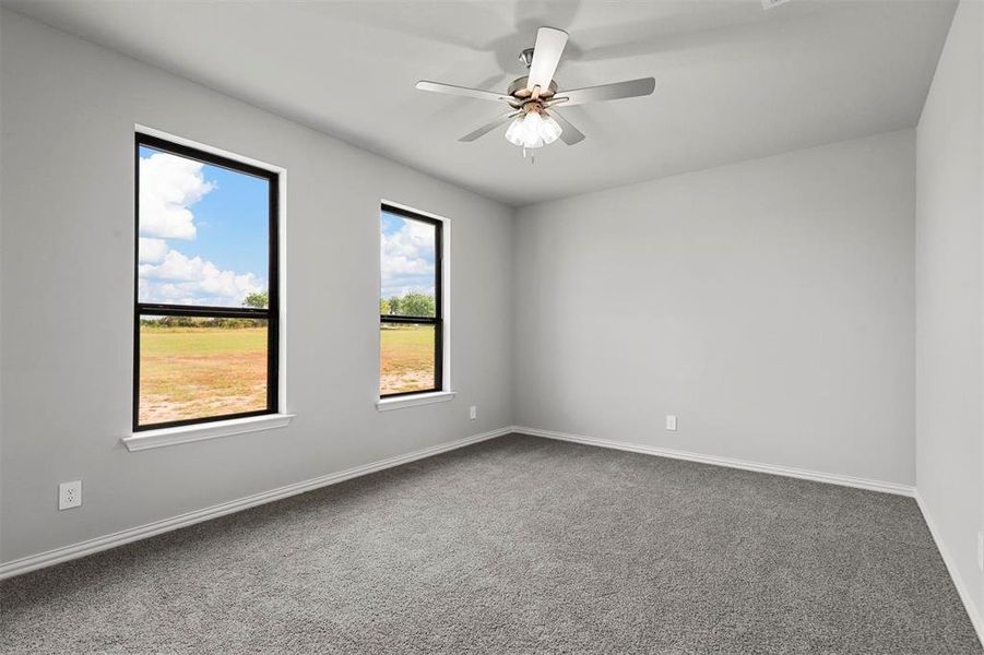 Carpeted spare room featuring ceiling fan