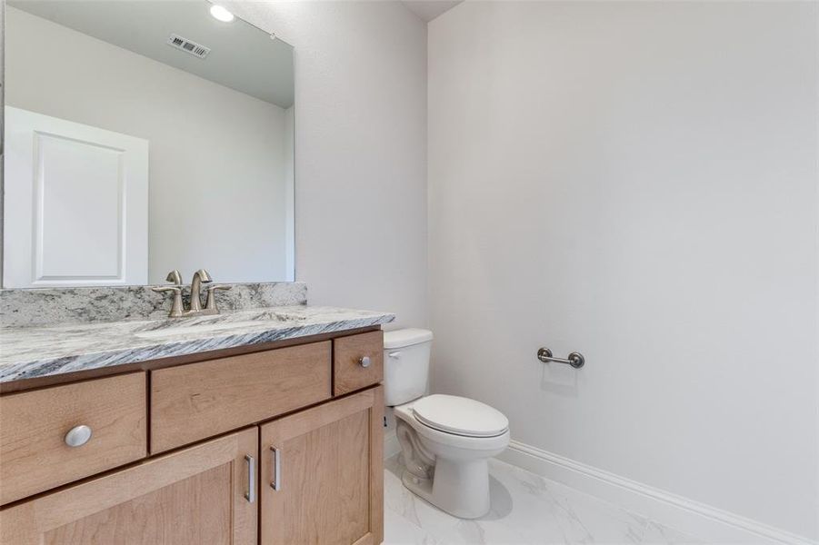 Half bathroom with vanity and light marble finish floors Half bathroom with vanity and light marble finish floors