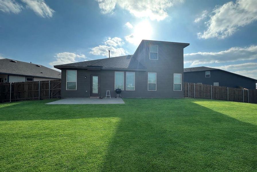 Rear view of property with a fenced backyard and a patio