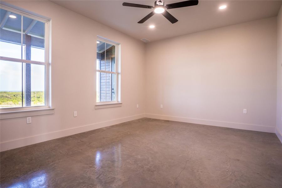 Spare room featuring finished concrete floors, ceiling fan, and recessed lighting