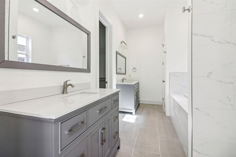 Full bathroom featuring two vanities, light tile patterned floors, and recessed lighting Full bathroom featuring two vanities, light tile patterned floors, and recessed lighting