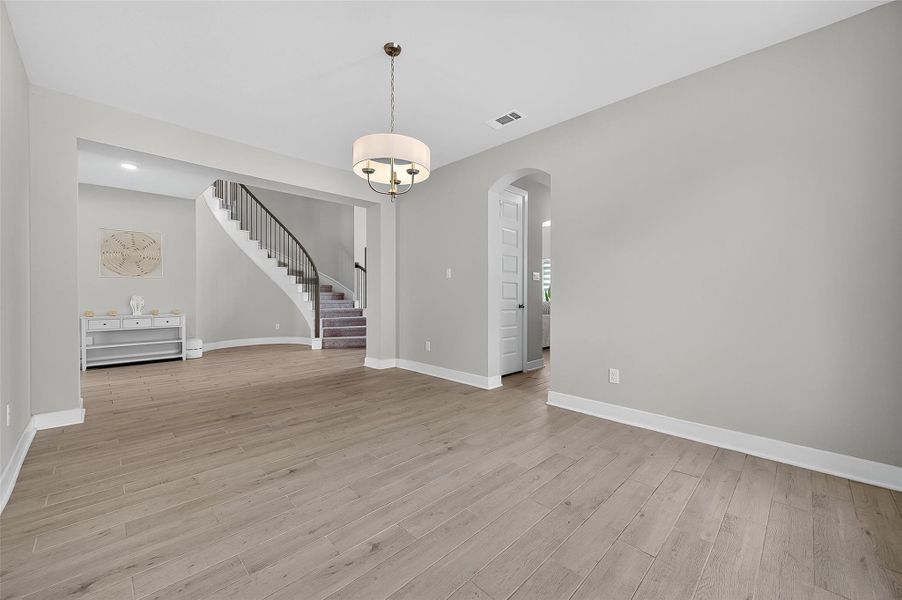 Positioned near the entry and adjacent to the kitchen, this dining space blends style and accessibility. The arched doorway and chandelier add timeless architectural charm.