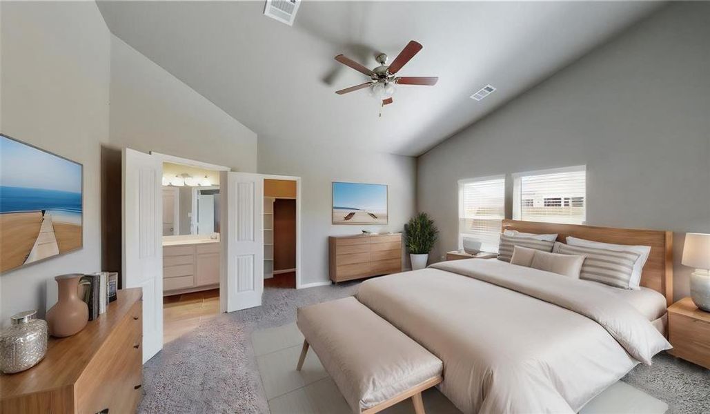 The primary bedroom offers a tranquil retreat with plush carpeting, a ceiling fan, and ample natural light from the large windows. The double doors lead to a private en-suite bathroom, ensuring a perfect blend of comfort and privacy. This is a picture of an Elise Floor Plan with another Saratoga Homes.