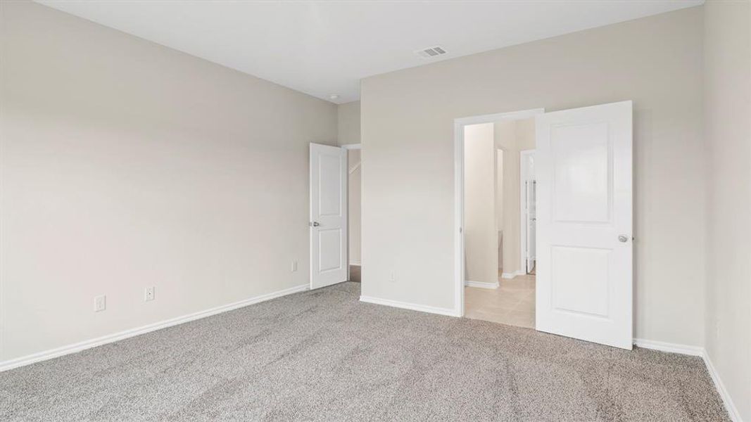 Spacious room with light neutral walls and gray carpet flooring