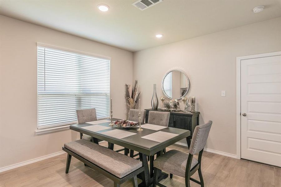 Dining room with light wood-type flooring and recessed lighting