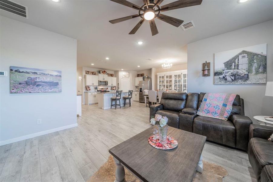 Living room with ceiling fan and light wood-type flooring