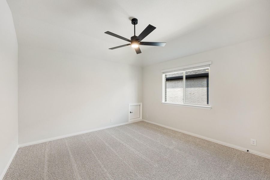 Empty bedroom with carpet flooring, black ceiling fan, and a single window with white trim Empty bedroom with carpet flooring, black ceiling fan, and a single window with white trim