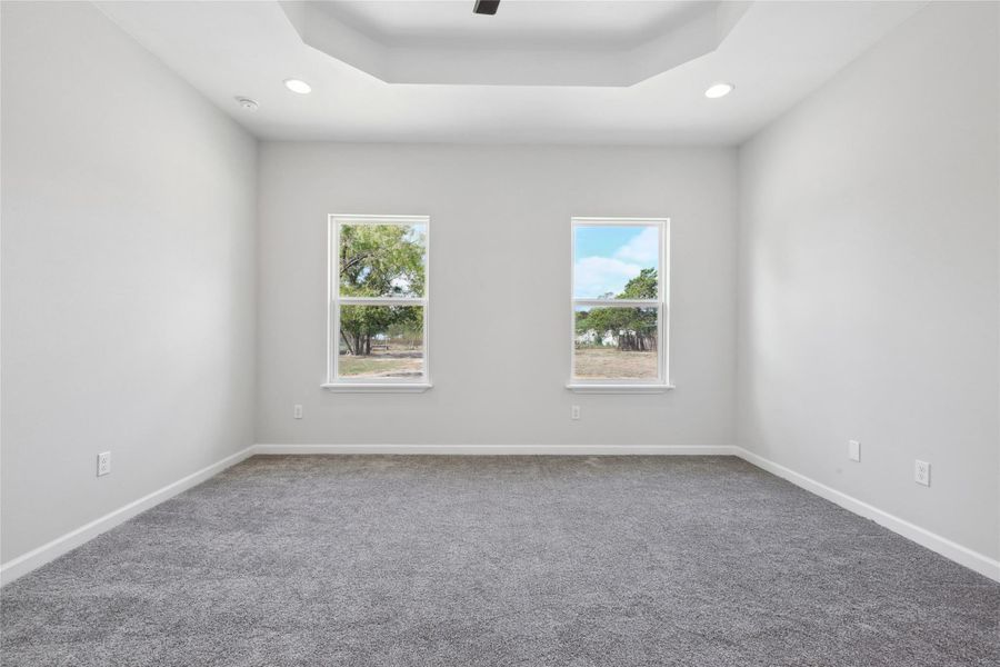 Spare room featuring carpet, recessed lighting, baseboards, a tray ceiling, and a ceiling fan Spare room featuring carpet, recessed lighting, baseboards, a tray ceiling, and a ceiling fan