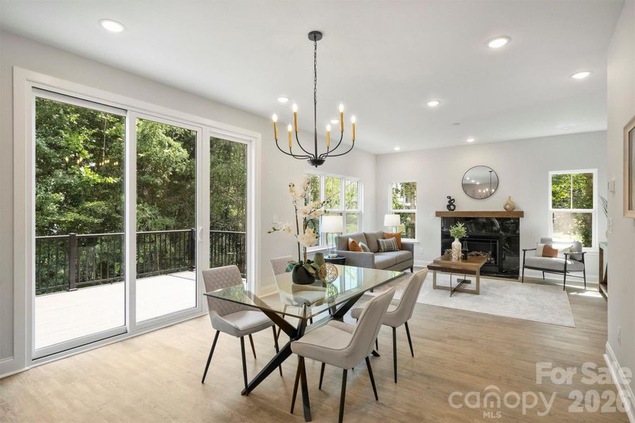 Dining area connecting the kitchen and living room, with glass sliding doors leading to the rear deck overlooking the backyard.