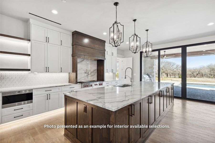 Kitchen with backsplash, a wealth of natural light, light hardwood / wood-style floors, and decorative light fixtures