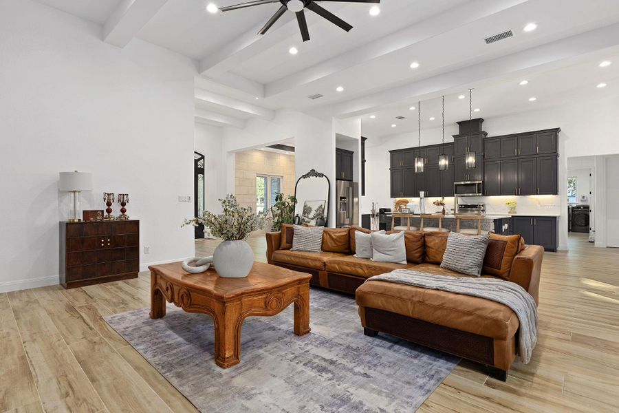 Living area featuring beam ceiling, light wood finished floors, ceiling fan, and recessed lighting Living area featuring beam ceiling, light wood finished floors, ceiling fan, and recessed lighting