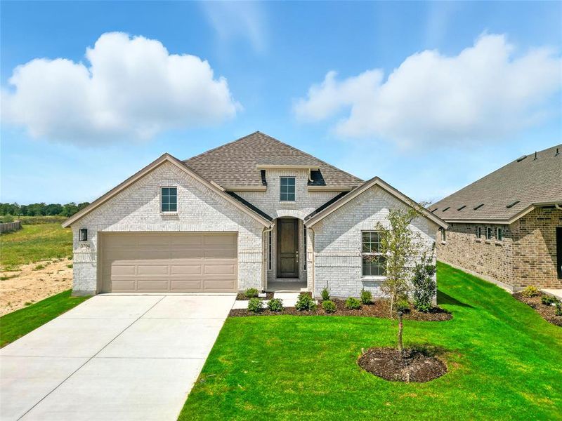 French provincial home featuring brick siding, roof with shingles, concrete driveway, a front lawn, and a garage French provincial home featuring brick siding, roof with shingles, concrete driveway, a front lawn, and a garage