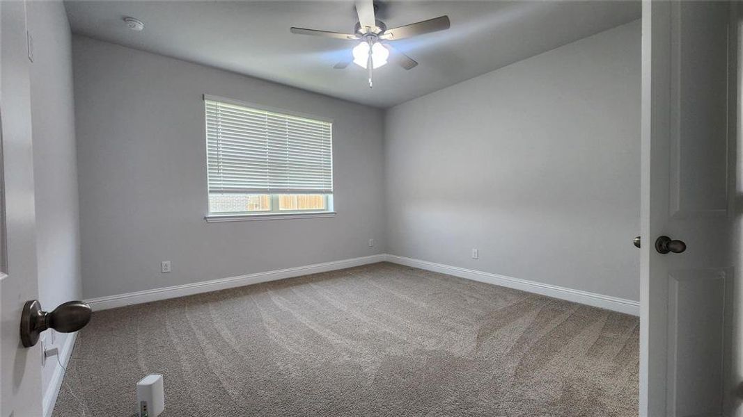 Spacious room featuring neutral carpeting, light gray wall paint, and white trim Spacious room featuring neutral carpeting, light gray wall paint, and white trim