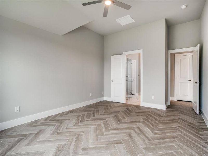 Unfurnished bedroom featuring connected bathroom, baseboards, and a ceiling fan