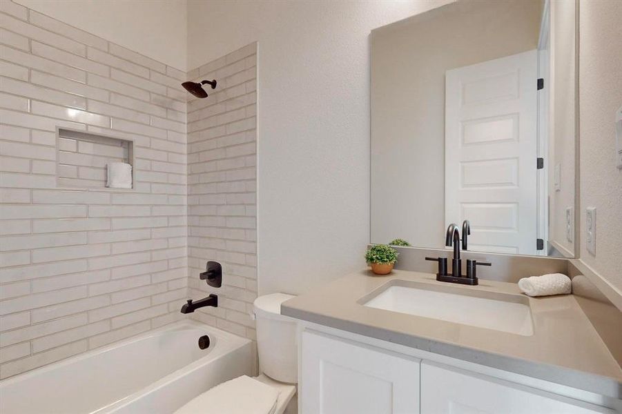 Bathroom with tiled shower / bath combo and vanity