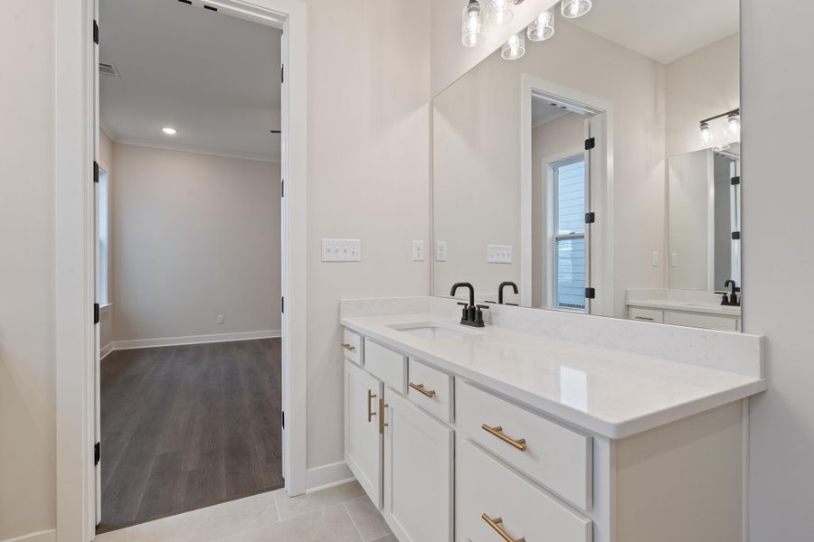 Bathroom featuring vanity, light tile patterned floors, and ornamental molding Bathroom featuring vanity, light tile patterned floors, and ornamental molding