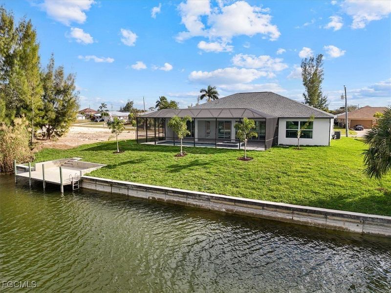 Dock area featuring a lanai, a sunroom, a lawn, and a water view