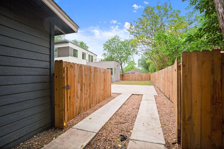 Property exterior featuring dark horizontal siding and a wood privacy fence