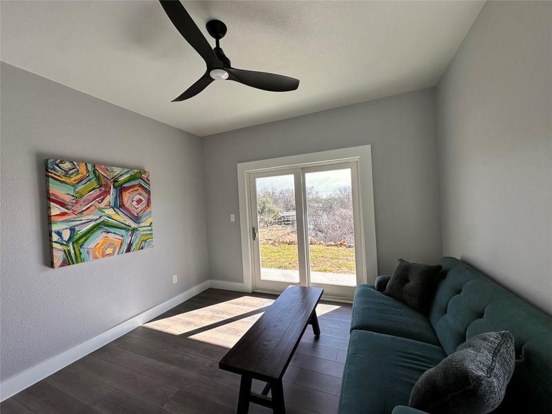 Living room with dark wood-style floors and ceiling fan Living room with dark wood-style floors and ceiling fan