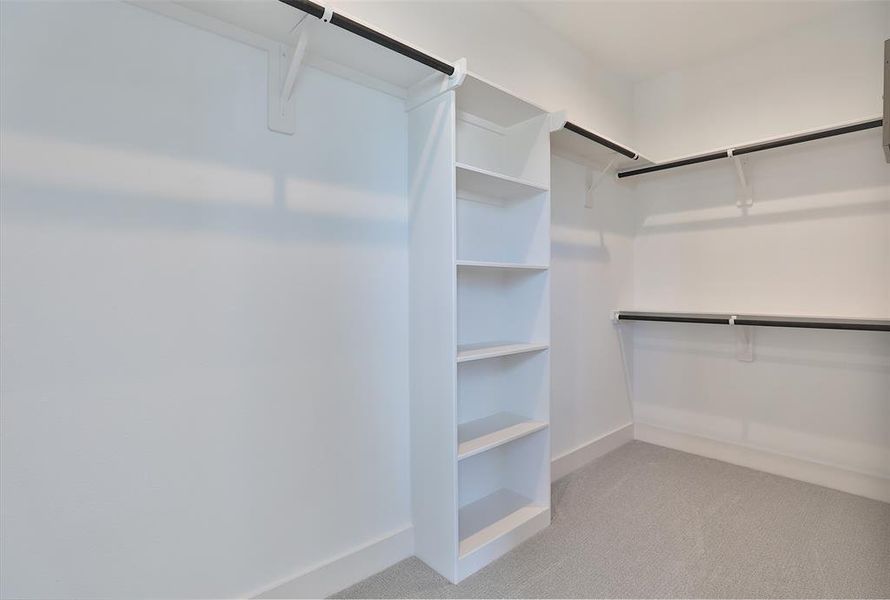 A spacious primary walk-in closet with plenty of room for shoes, accessories, and more.