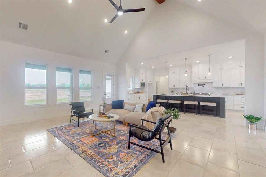 Living room with recessed lighting, high vaulted ceiling, beamed ceiling, a ceiling fan, and light tile patterned floors Living room with recessed lighting, high vaulted ceiling, beamed ceiling, a ceiling fan, and light tile patterned floors
