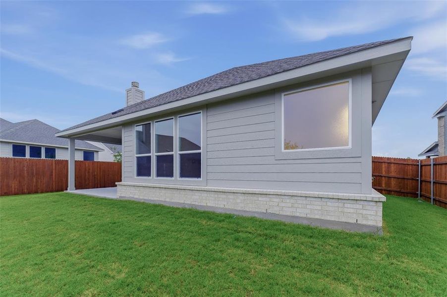 Expansive green lawn with a wooden privacy fence