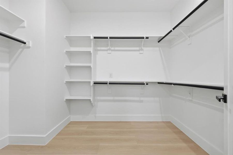 Walk in closet with light wood-style flooring