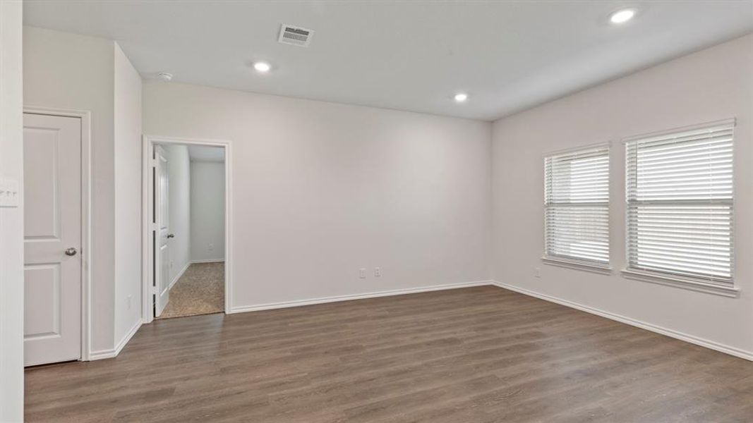Room featuring wood-finish flooring, recessed lighting, and light-toned walls