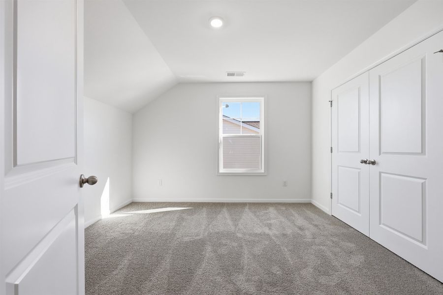 Additional living space featuring carpet and vaulted ceiling Additional living space featuring carpet and vaulted ceiling