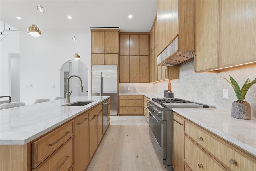 Kitchen featuring an expansive island with a stainless steel sink and gooseneck faucet Kitchen featuring an expansive island with a stainless steel sink and gooseneck faucet