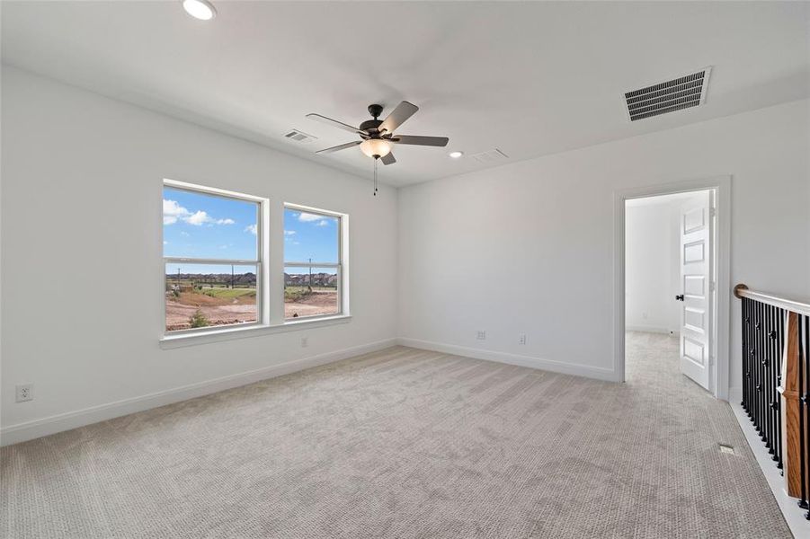 Unfurnished room with ceiling fan and light carpet