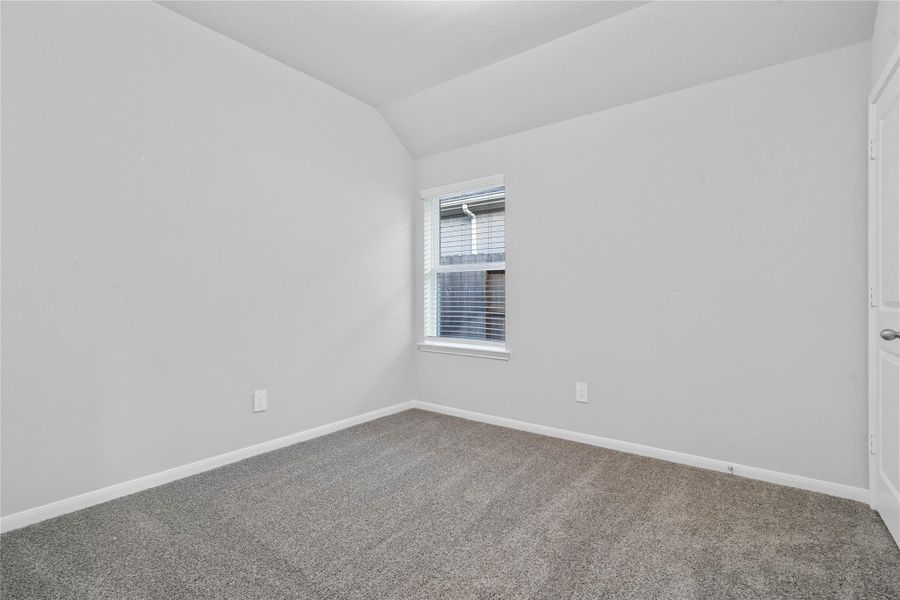 Perfect for guests or a quiet home office, this room features soft plush carpeting, a window with fitted blinds, sloped ceiling, and ample sized closet space.