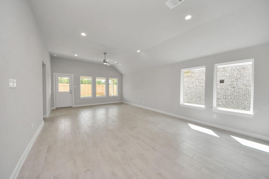 Gather the family and guests together in your lovely living room! Featuring soaring high ceilings, recessed lighting, ceiling fan, custom paint, gorgeous floors, and large windows that provide plenty of natural lighting throughout the day. Sample photo of completed home with similar floor plan. Actual colors and selections may vary.