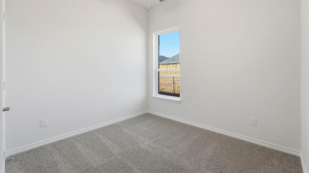 Empty room with carpet flooring and baseboards Empty room with carpet flooring and baseboards