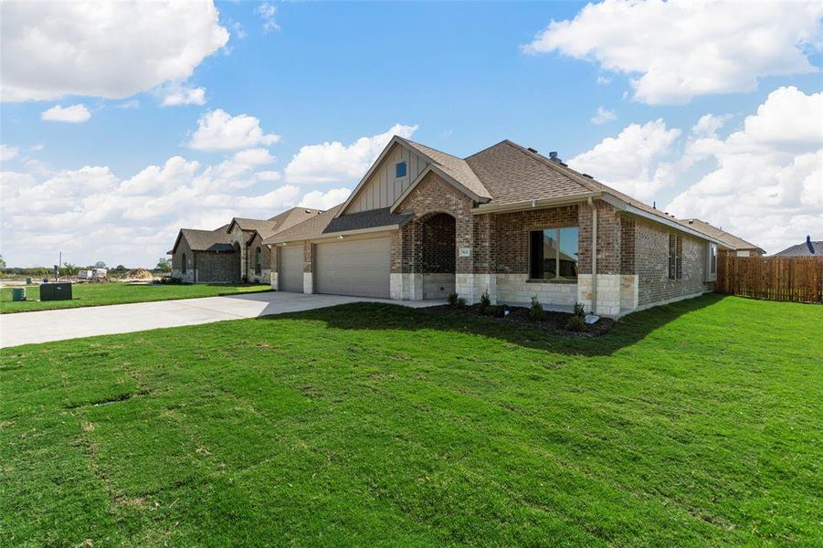 Single story home with a garage and a front lawn