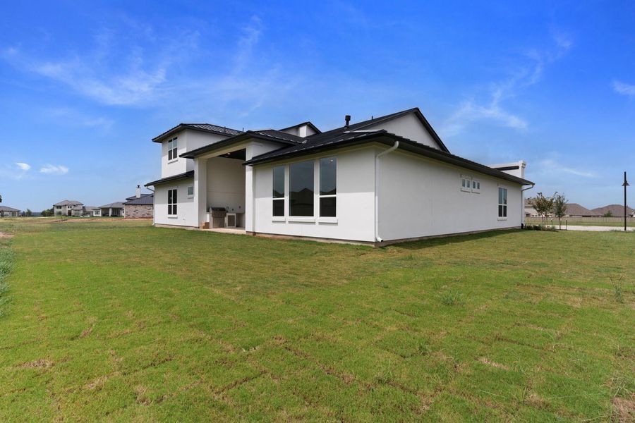 Modern architecture defines this dwelling, complemented by a vibrant green yard under an open sky. Modern architecture defines this dwelling, complemented by a vibrant green yard under an open sky.