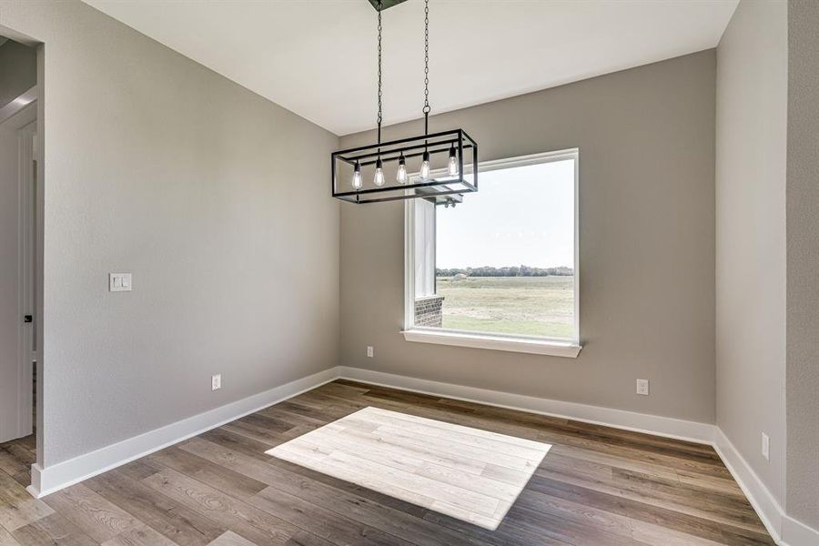 Unfurnished dining area with a chandelier and hardwood / wood-style flooring