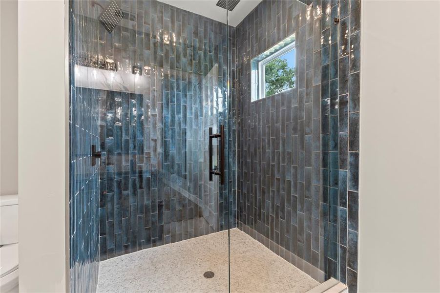 Frameless shower surrounds with spacious walk-in tile shower.