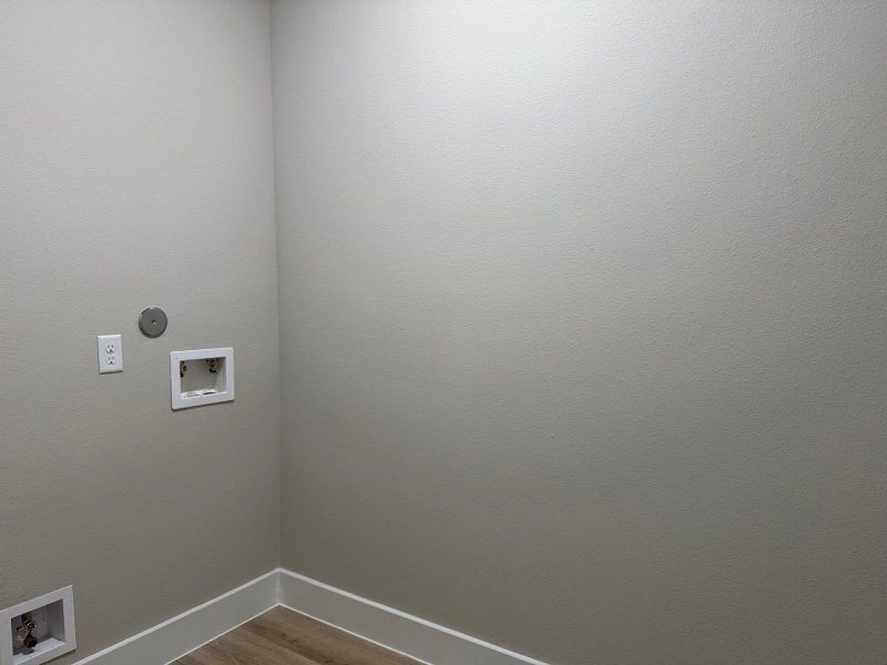 Spacious laundry area with plumbing and electrical ready for your appliances, offering convenience and efficiency.