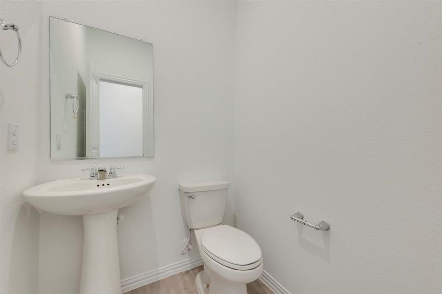 Bathroom with hardwood / wood-style flooring and toilet