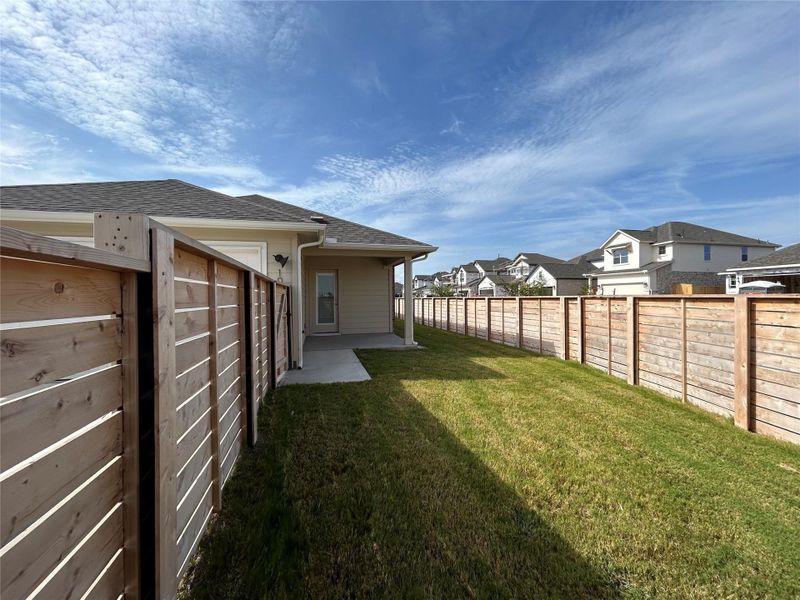 Fenced backyard with a residential view and a patio Fenced backyard with a residential view and a patio